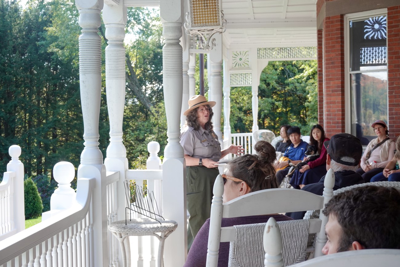 park ranger talks to group of visitors on mansion porch