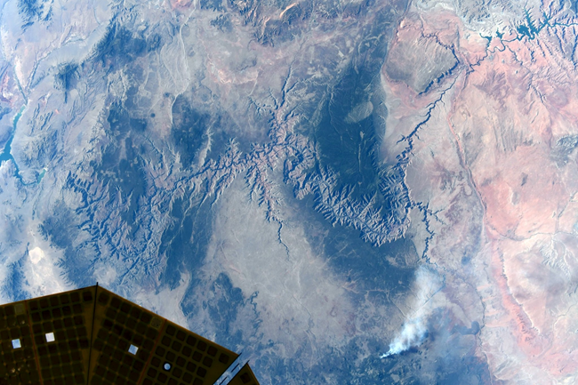 Grand Canyon from space. A green and brown landscape with a long jagged canyon cut into the Earth.