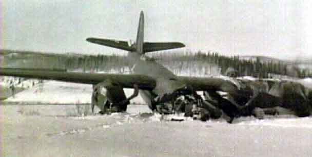 black and white photo of an airplane crashed into the snow.