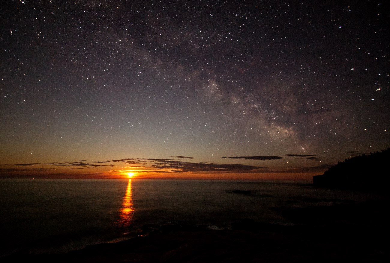 the moon rises over the ocean