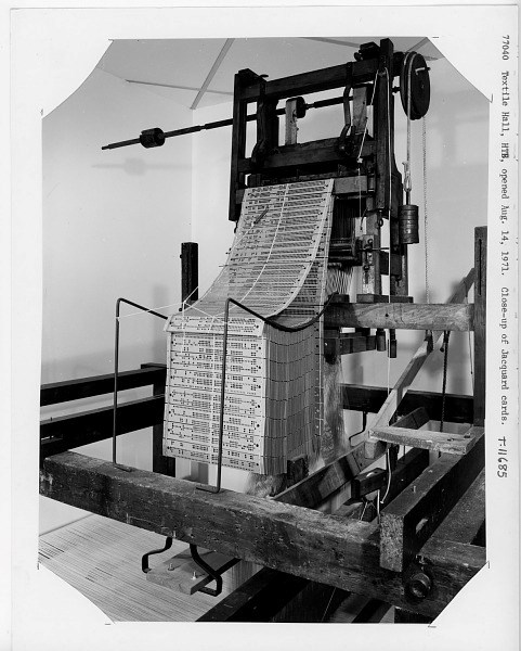 black and white historic photo of a machine with rows of material full of small holes