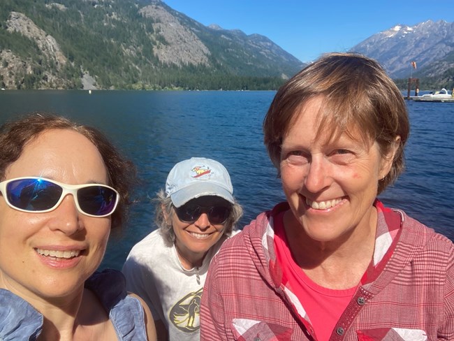 Sarah and two people in front of a lake