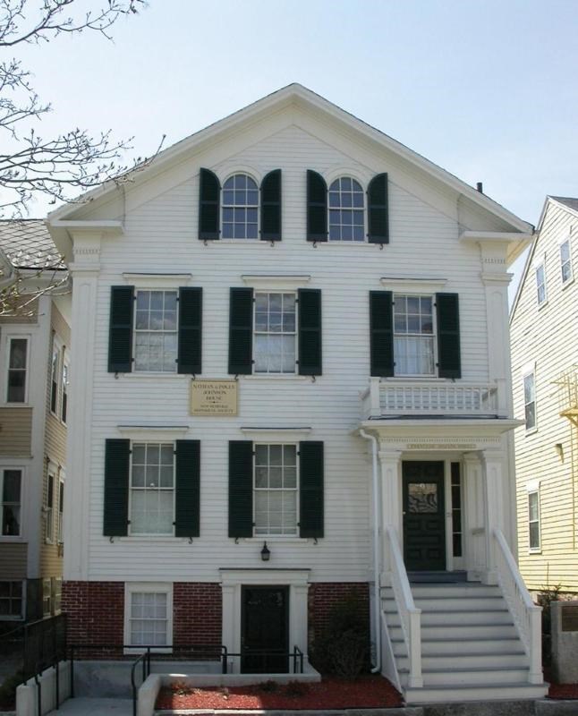 A three story white house with green shutters has a sign that reads "Nathan and Polly Johnson House - New Bedford Historical Society."