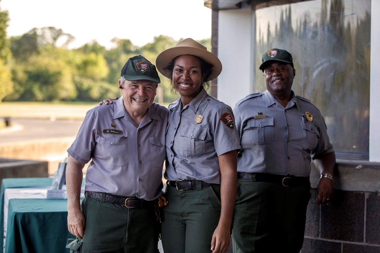 Three people in NPS uniform smiling at the camera