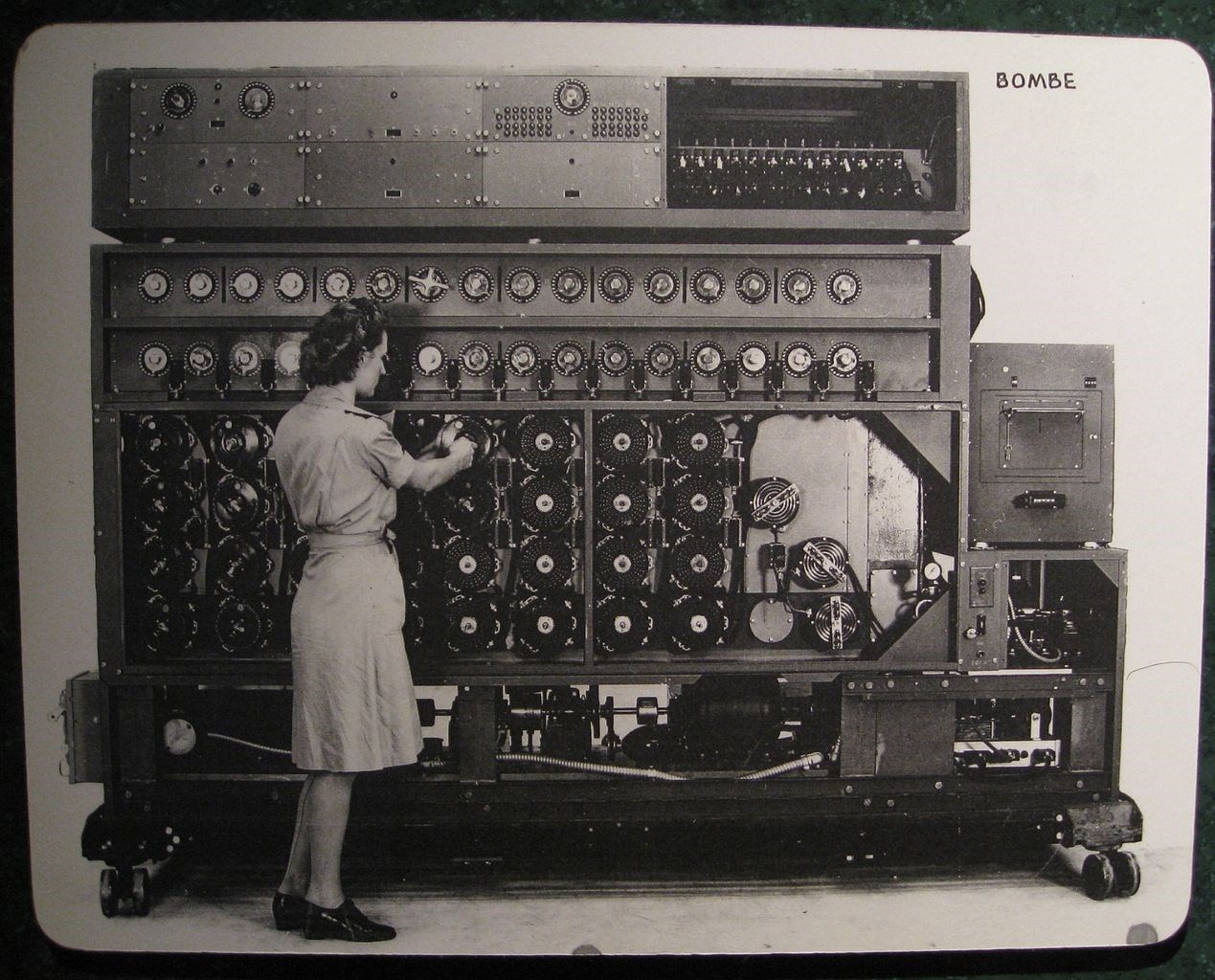 A female operator sets the rotors on a US Navy bombe, a massive electromechanical codebreaking machine, prior to a run.