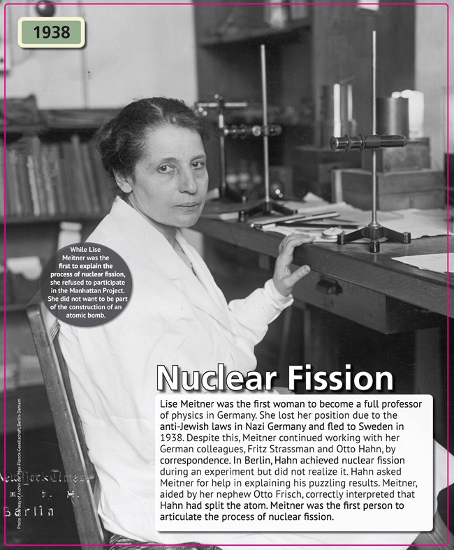 A black-and-white photograph of a middle-aged woman seated in a white lab coat before a laboratory table.