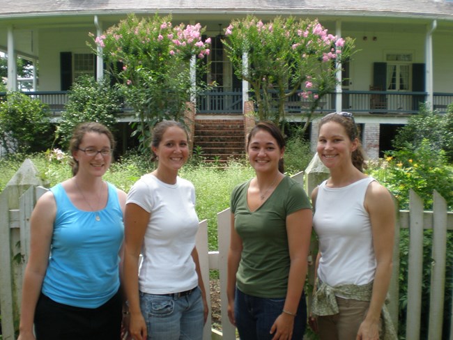 NCPTT interns Anna Muto, Kim Martin, Caitlin Oshida and Stephanie Nelson at Oakland Plantation with the plantation house and garden in the background.