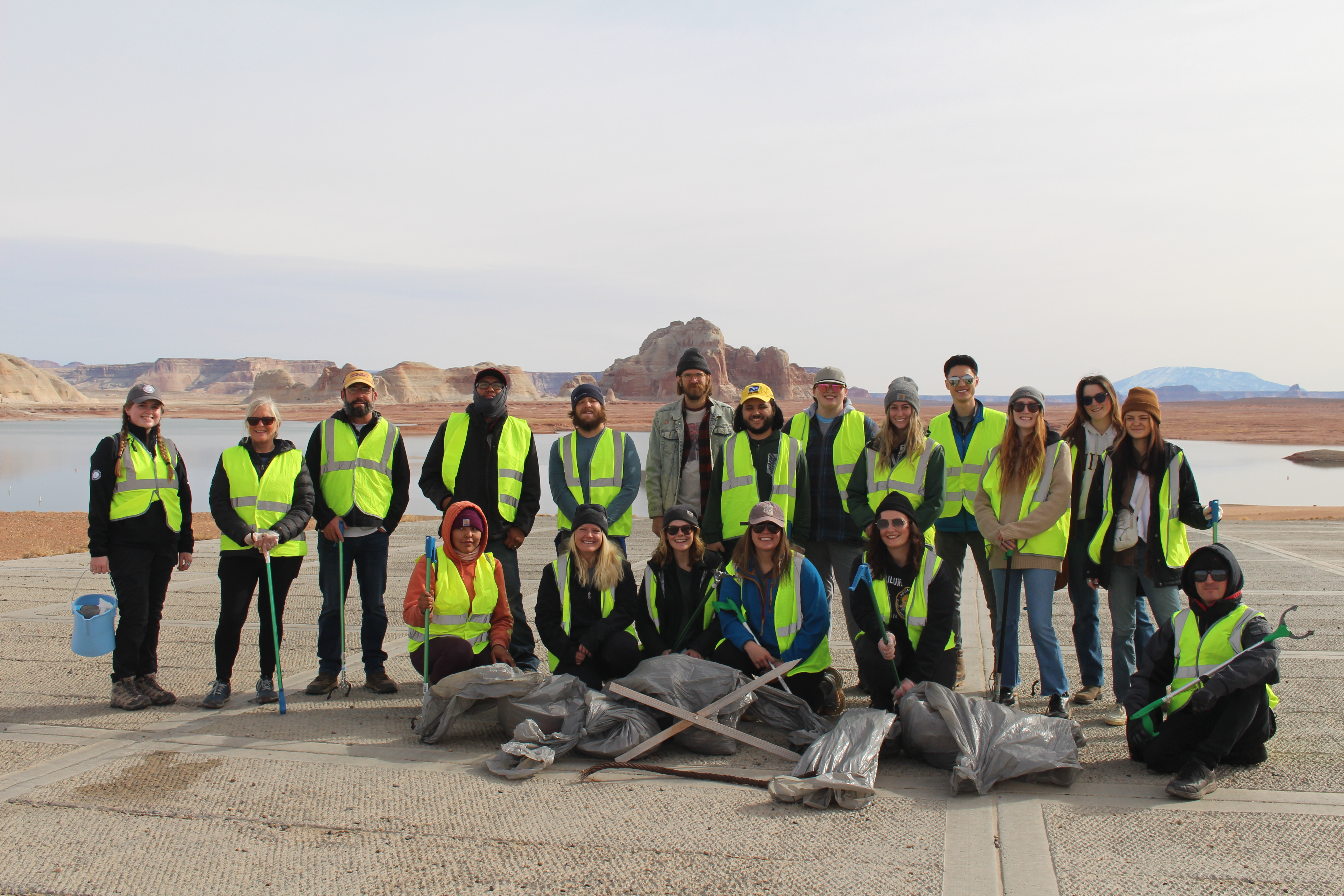 Group of people pictured together in front of collected trash.