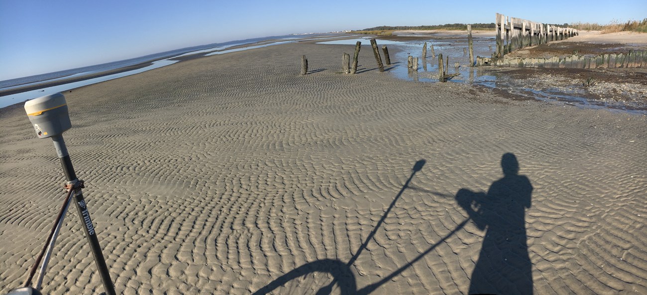 intern ans her shadow on a beach while working