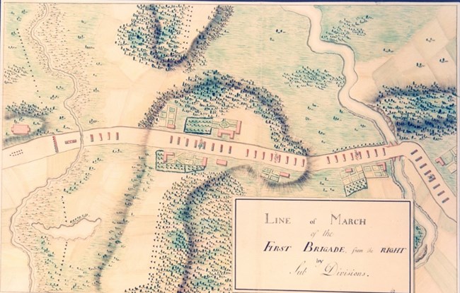 An 18th Century watercolor image of a landscape shown from above including trees, houses, road, river and bridge. Colored rectangles indicate units of soldiers in the roadway.