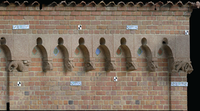 Color photogrammetric rendering of a several sculptural elements on the façade of the Reptile House with several black and white targets and long color rectangular scale bars temporarily attached to a brick wall.