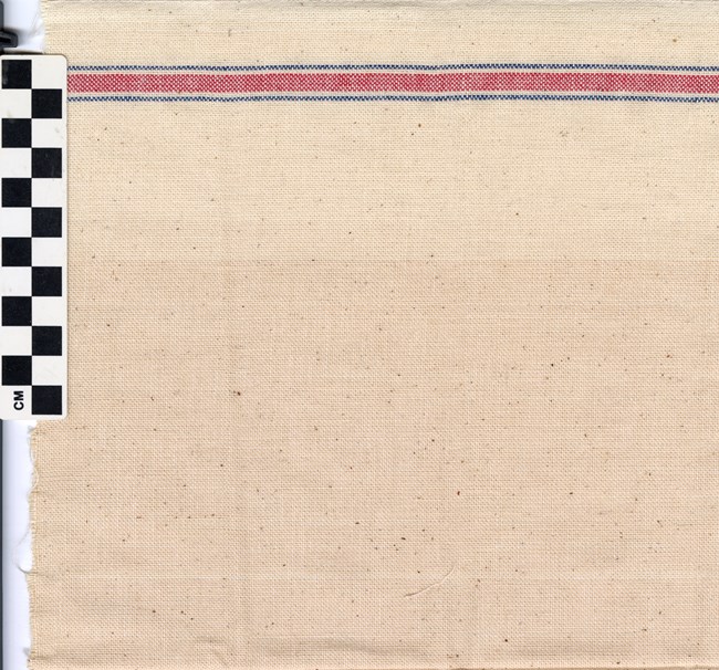 Image of woven cloth with a thin blue stripe, thick red stripe, and another thin blue stripe at the top. In the top left corner is a black and white checkered rectangle