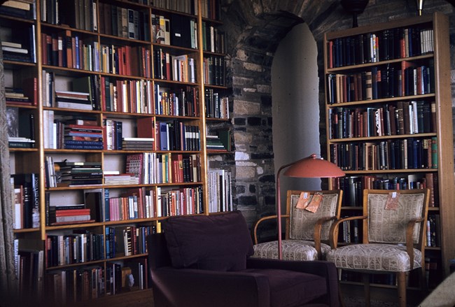 A room with stone walls and tall bookcases