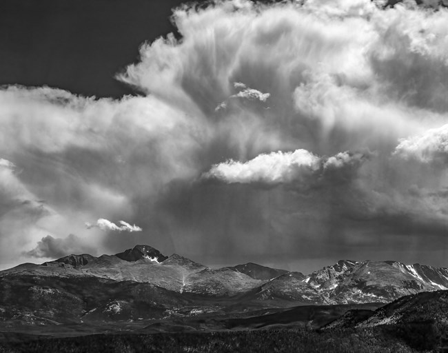 Black and white image of large clouds over a mountain