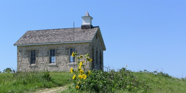 Limestone one room schoolhouse against a blue sky