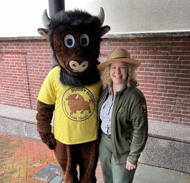 A woman posing with Buddy the Bison, a mascot for the National Park Trust.