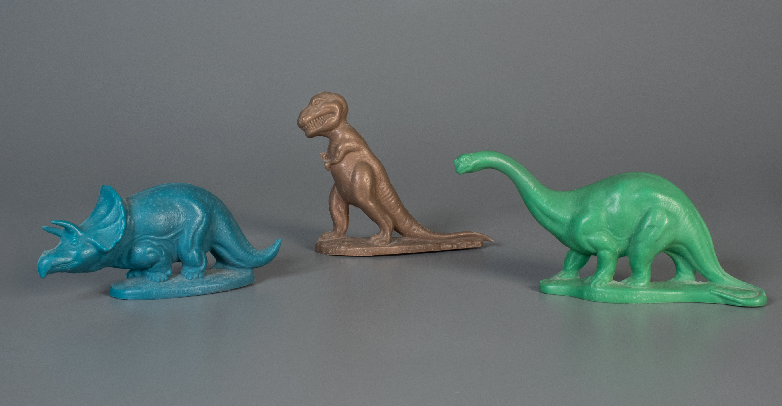 Three toy dinosaurs on display
