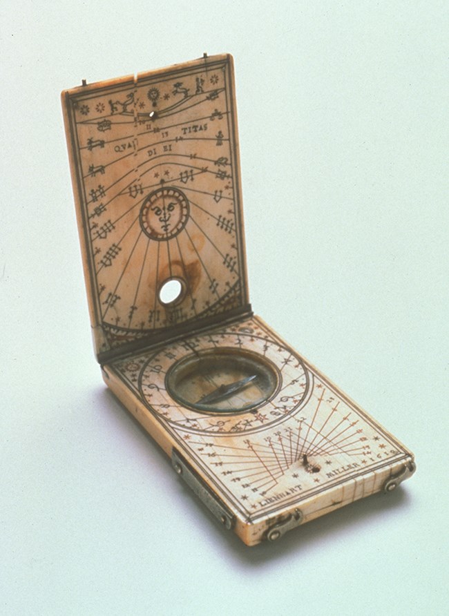 A folding sundial with a compass made of ivory with carved astronomical decorations