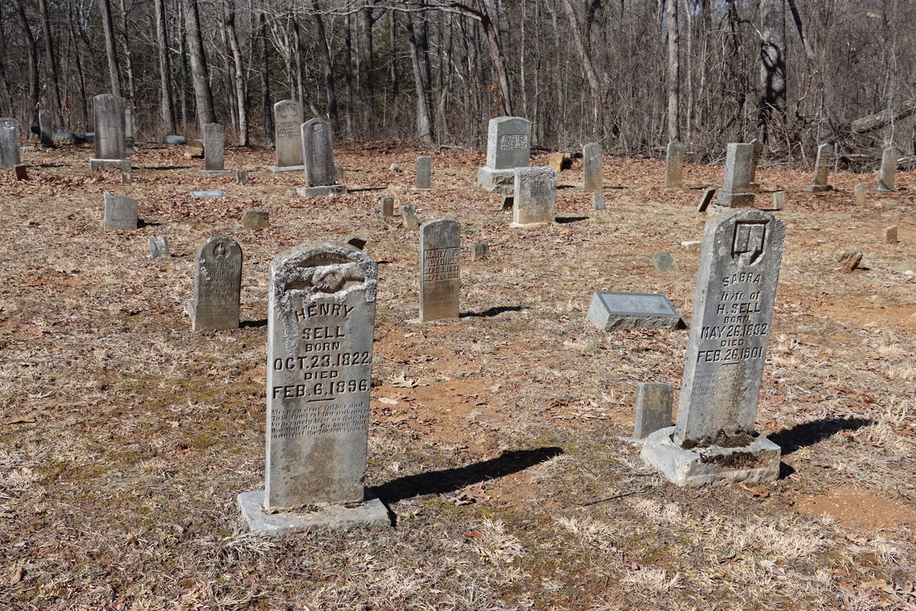 Gray stone grave markers display a variety of symbols.