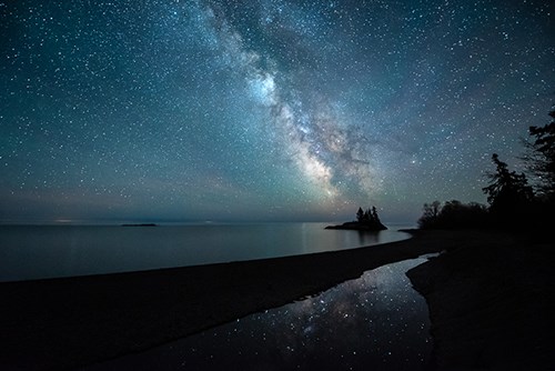 Milky Way with silhouetted landforms.