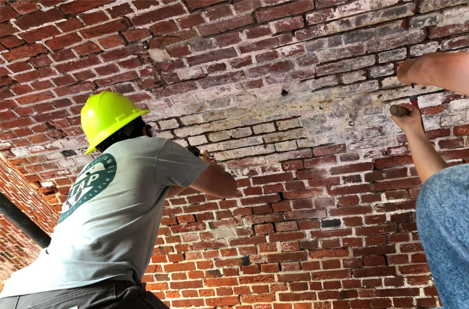 Young men repairing masonry joints