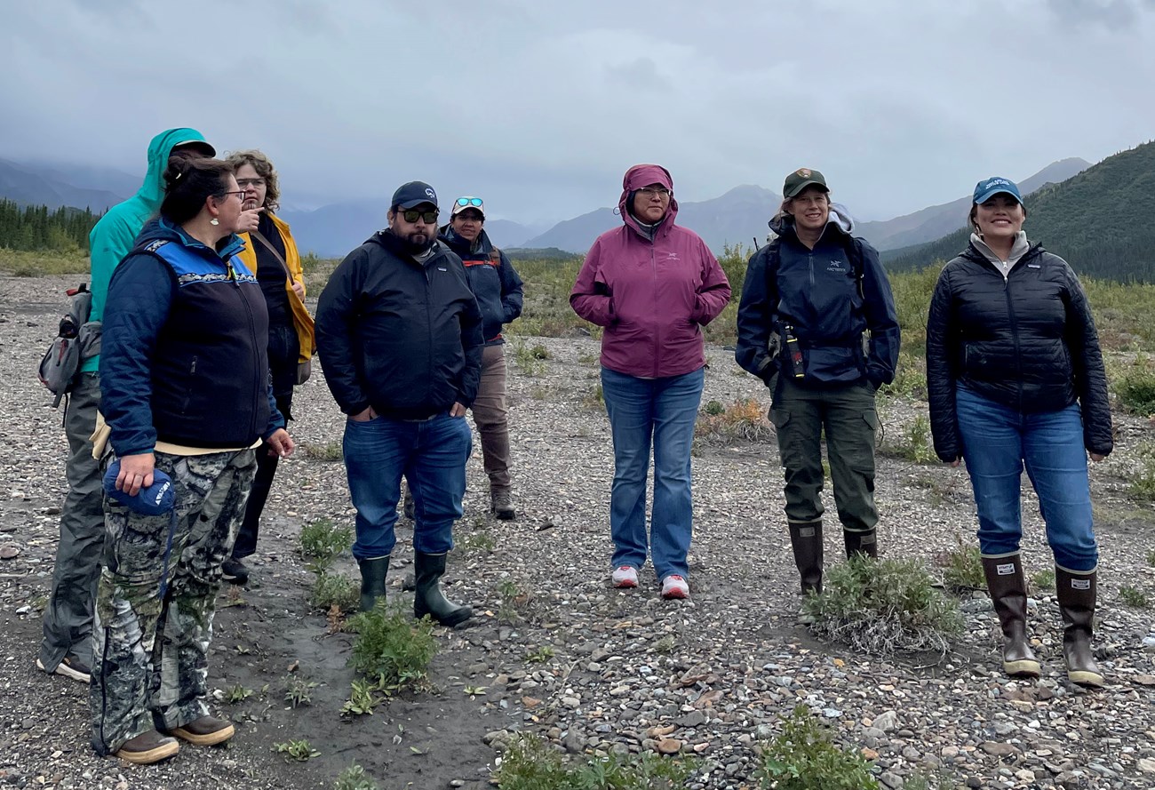 Group of people outside in a mountainous landscape on an overcast day.