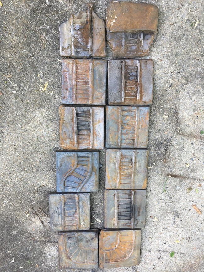 Twelve cast iron squares depicting a series of parallel train tracks