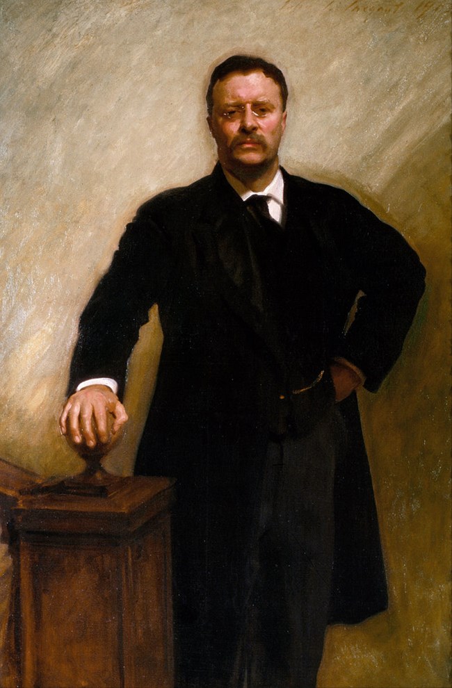 A painting of Theodore Roosevelt depicts him glaring at the viewer with one hand on his hip and the other gripping an orb-shaped cap of a newel post.