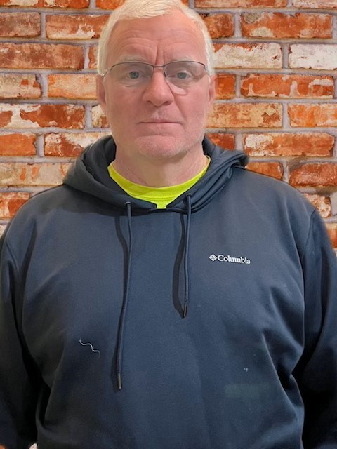 A portrait of a man wearing a sweatshirt.