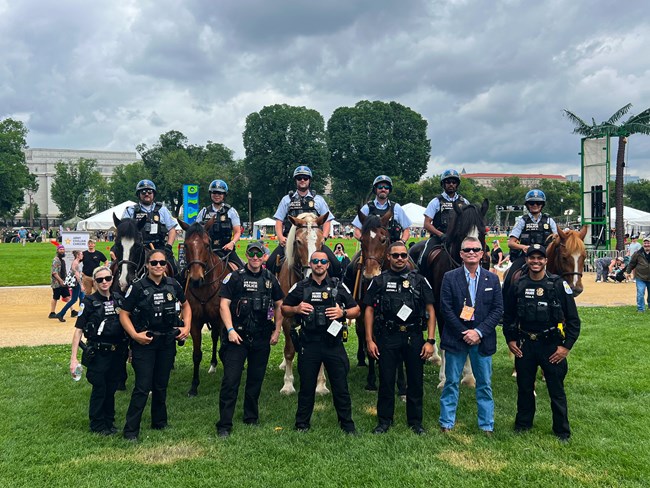 A group of police officers on foot and on horses pose for a group photo on the National Mall.