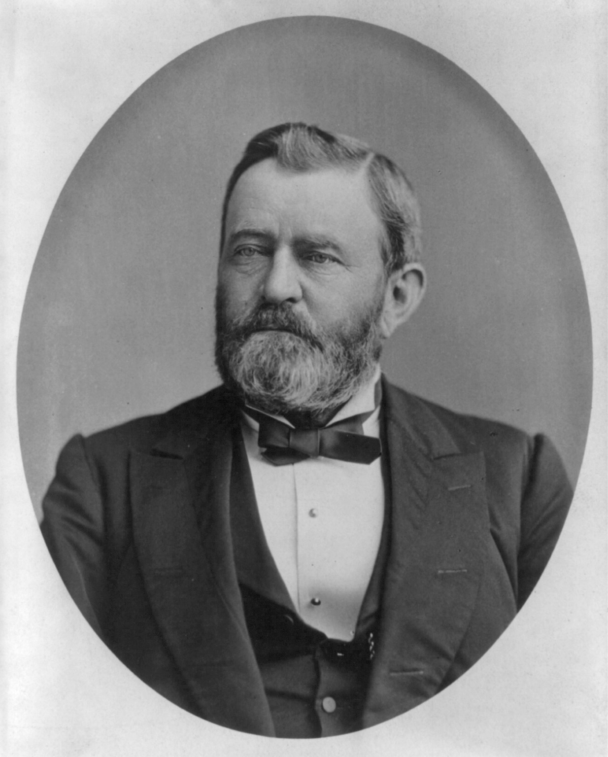 Black and white portrait of a middle aged bearded man wearing suit and bow tie.