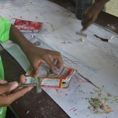 Youth participating in a creative activity using post-consumer materials.