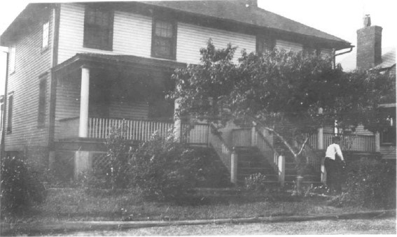 a man stands in front of a historic multi-family home