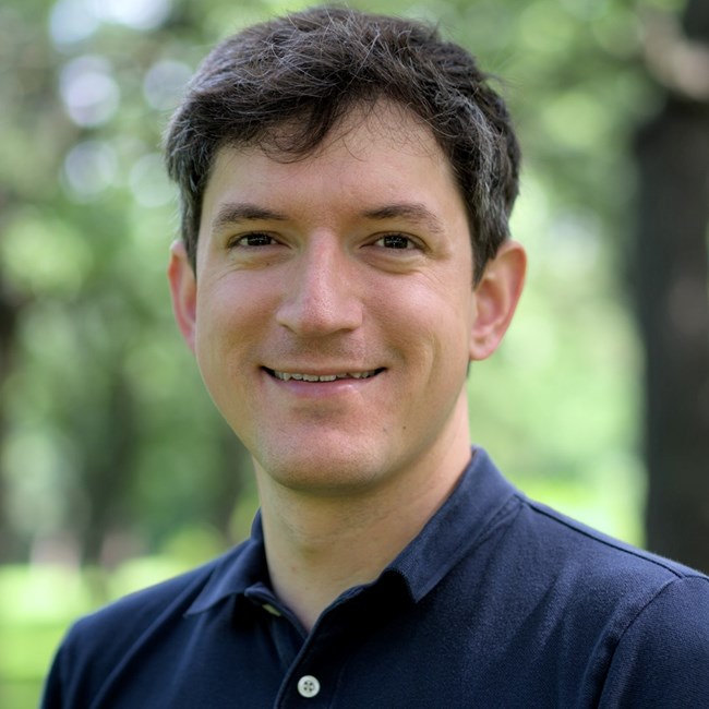 A white man with brown hair wearing a blue shirt