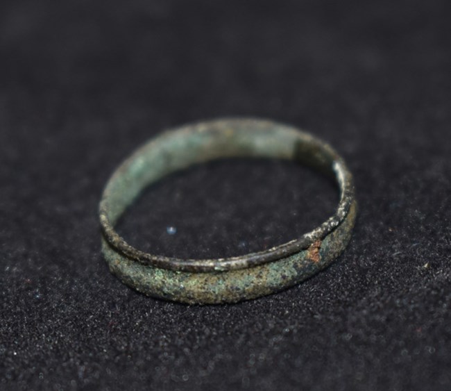 An old ring with a small hole, emphasizing its craftsmanship and historical context
