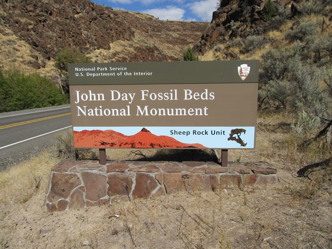 John Day Fossil Beds Entrance Sign outside a basalt canyon.