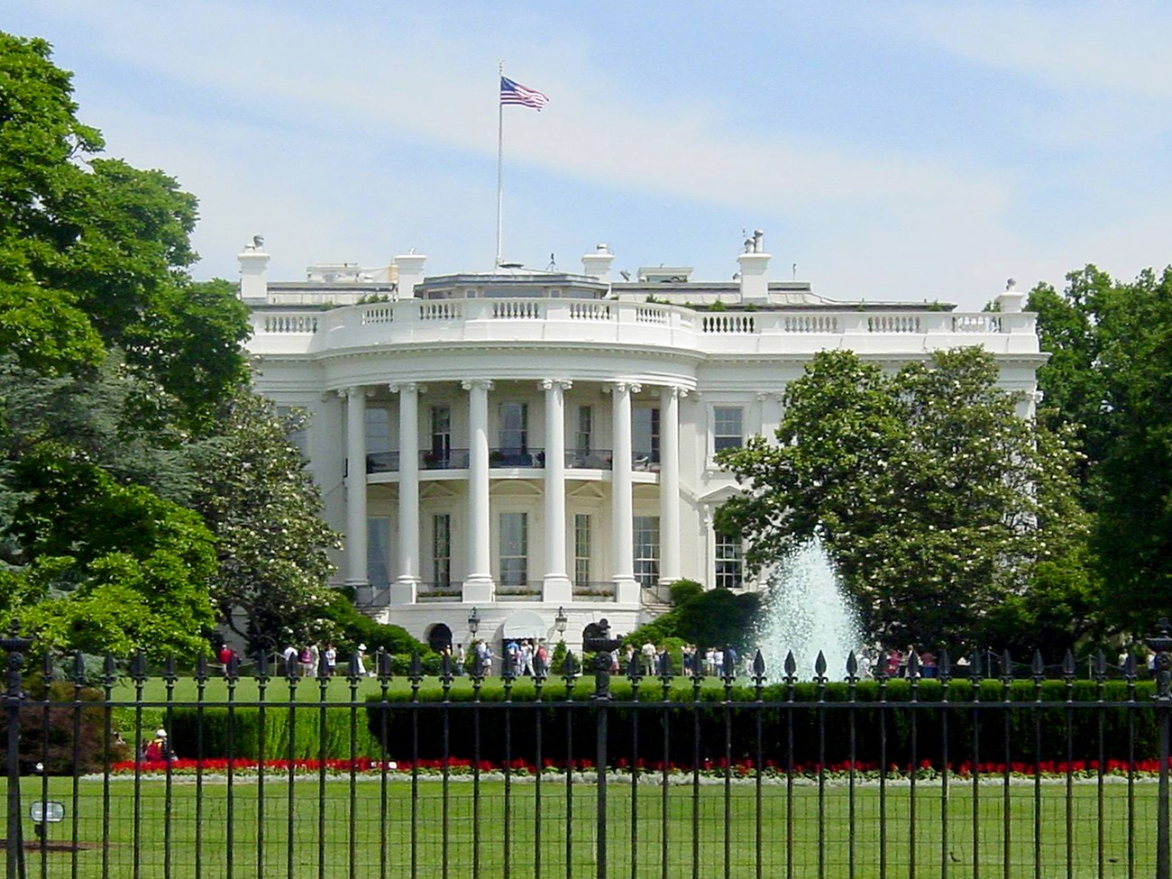 View of the White House and grounds from behind an iron fence