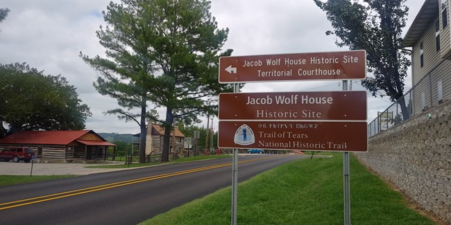 A large brown sign next to a road.