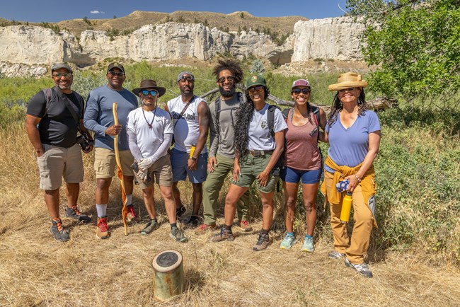 Eight adventurers stand at a Lewis and Clark Expedition campsite marker at Upper Missouri River Breaks National Monument, Montana