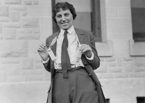 Temporary Ranger Frieda Nelson holds out her suspenders and smiles for the camera.