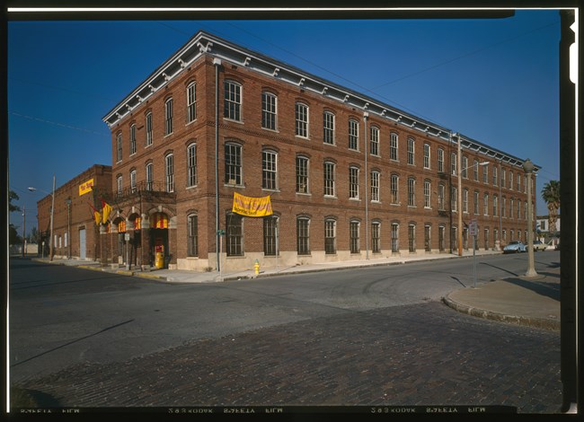 Three-story brick building with yellow banner