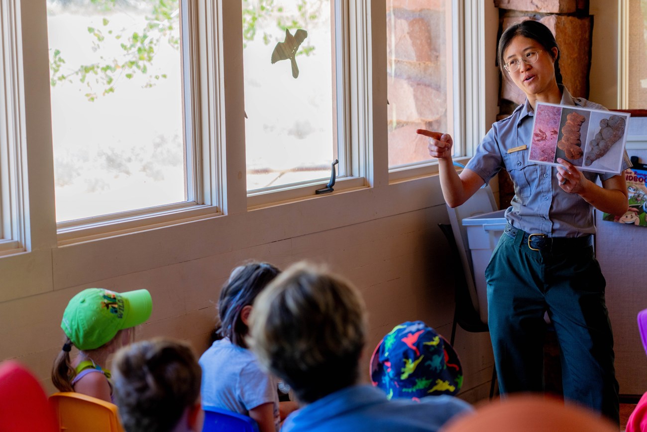 Park ranger talking to kids inside a classroom