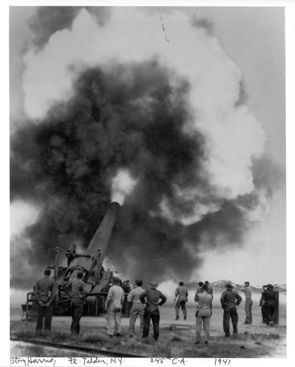 soldiers stand around a large battery gun firing