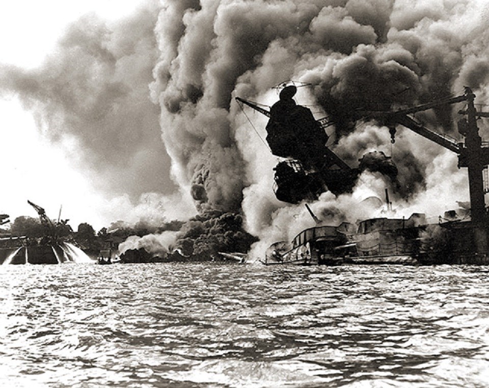 black and white photo of billowing smoke from a ship, as it tips into the water.