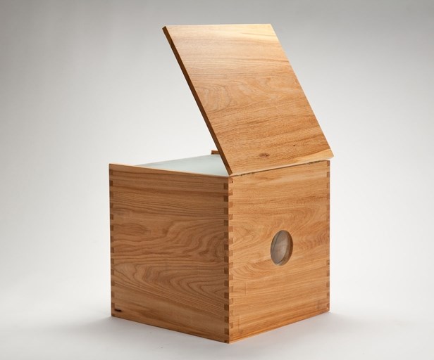 Wooden cube box with a small hole on one side and one side of the box is open