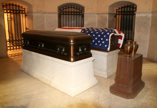 caskets on display with an American draped over it