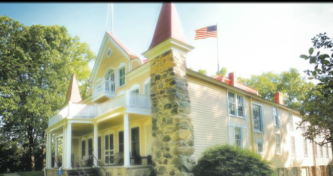 house is yellow with a white porch on the top part of the home