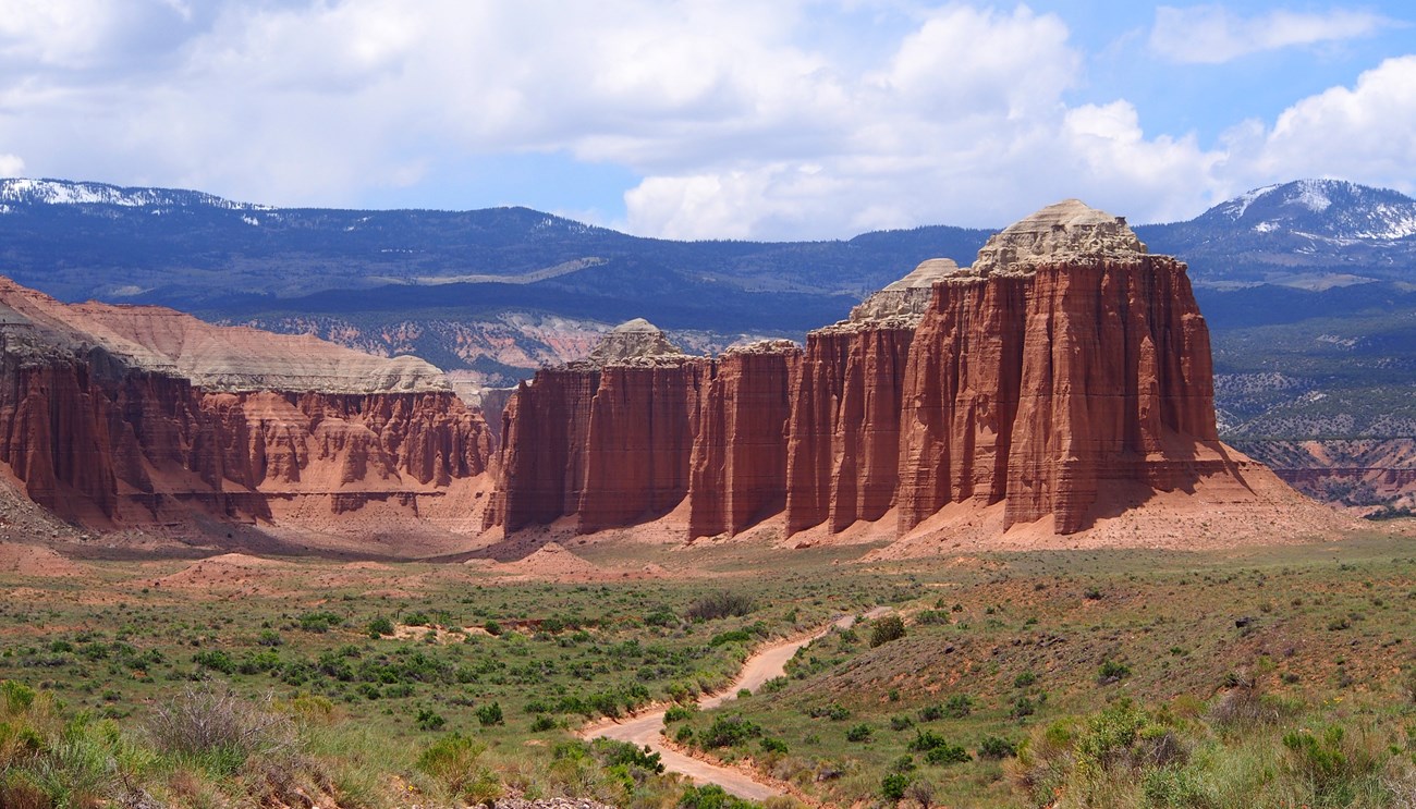 Red rock monoliths rise above desert shrublands in Cathedral Valley at Capitol Reef National Park.