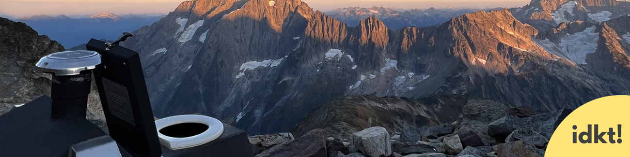 a wilderness toilet with a view of jagged peaks