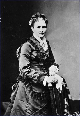 First Lady Garfield is sitting for a photographer wearing a dark colored dress